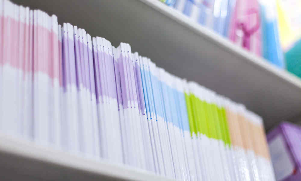A shelf of research publications with different coloured spines.