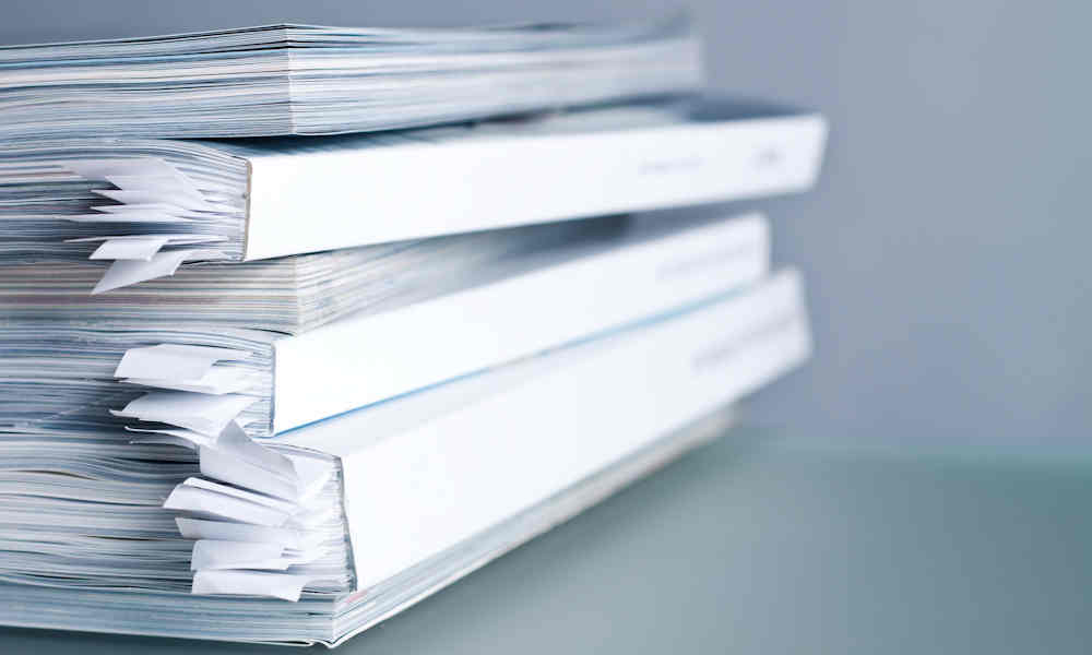 A stack of publications with page markers in them.